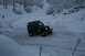 1990 Chevrolet Suburban - A Jeep Wrangler navigates a snow-covered path surrounded by trees.