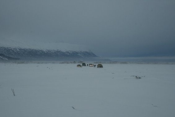 Group of SUVs in a snowy landscape with a mountain range in the background