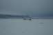 1990 Chevrolet Suburban - Several SUVs are gathered in a vast, snow-covered area, with a distant mountain range under a cloudy sky.