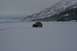 1990 Chevrolet Suburban - A yellow pickup truck traverses a vast, snow-covered landscape under a cloudy sky.