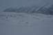 1990 Chevrolet Suburban - A wide expanse of snow covers the ground, leading to a textured glacier and distant, mist-shrouded mountains.