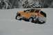 1990 Chevrolet Suburban - SUV stuck in snowdrift with visible damage to rear passenger side.
