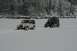 1990 Chevrolet Suburban - Two Jeep Wranglers navigate a snowy landscape, kicking up snow as they drive.