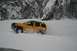 1990 Chevrolet Suburban - SUV navigating a snowy landscape with steep, tree-covered mountains.