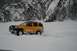 1990 Chevrolet Suburban - SUV navigating a snow-covered landscape near a mountain.