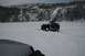 1990 Chevrolet Suburban - A dark green Jeep Wrangler navigates a snowy landscape, with a portion of another vehicle visible in the foreground.