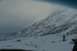 1990 Chevrolet Suburban - A vast, snow-covered mountain dominates the frame under a muted, overcast sky.