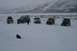 1990 Chevrolet Suburban - Group of off-road vehicles in a snowy, mountainous terrain with two people visible.