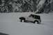 1990 Chevrolet Suburban - A white Jeep Wrangler navigates a snowy landscape, its brown hardtop contrasting with the white exterior.