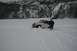 1990 Chevrolet Suburban - A white Jeep Wrangler struggles to move through deep snow near a snow-covered mountainside.