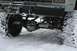 1990 Chevrolet Suburban - Vehicle's front axle and suspension system are visible in a snowy environment, with a winch mounted on the bumper.
