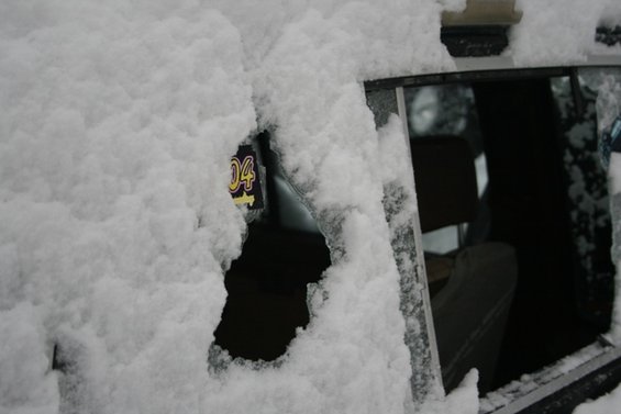 Vehicle interior with snow on window, showing "04" on a tag