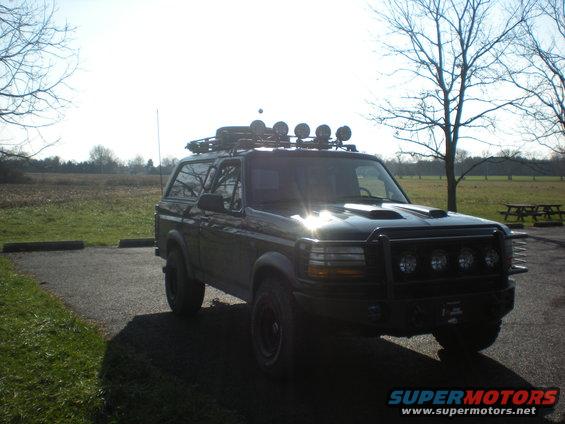 1993 Ford Bronco with roof rack, off-road lights, and brush guard parked outdoors