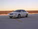 2003 Acura TL - A white 2003 Acura TL is parked on a concrete surface with yellow lines, under a clear sky.