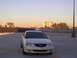 2003 Acura TL - A white sedan is parked on a rooftop with city buildings in the background.