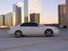 2003 Acura TL - Side view of a white 2003 Acura TL parked on a rooftop with modern skyscrapers in the background.