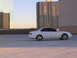 2003 Acura TL - A white sedan is parked on a rooftop with tall buildings in the background.