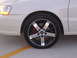 2003 Acura TL - Aftermarket wheel and tire assembly on a white vehicle, showing red brake caliper.