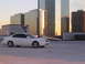 2003 Acura TL - A white 2003 Acura TL is parked on a rooftop with a backdrop of modern glass skyscrapers.