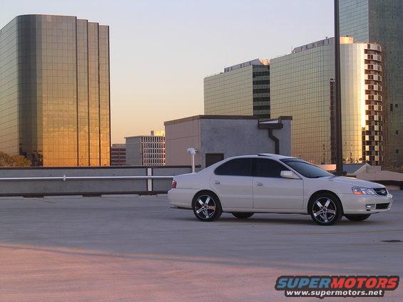 2003 Acura TL parked on a rooftop with modern buildings in the background