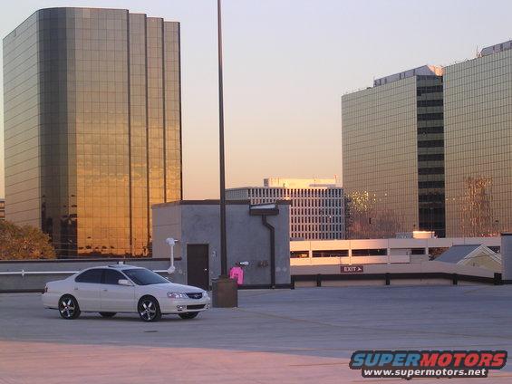 2003 Acura TL parked on rooftop, golden hour lighting on buildings