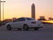 2003 Acura TL - A white sedan is parked on a rooftop during sunset, with city buildings in the background.
