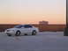 2003 Acura TL - A white 2003 Acura TL sedan is parked on a rooftop during sunset, with a building visible in the background.