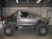 1984 Ford Bronco II - Customized pickup truck with off-road modifications and a full roll cage, viewed from the side.