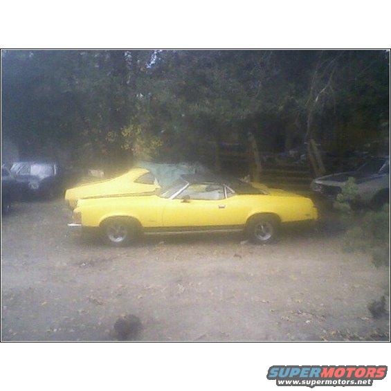 Yellow 1973 Mercury Cougar convertible parked next to another car
