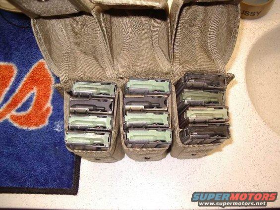 Tactical pouch holding multiple rifle magazines. A blue and orange towel is visible to the left