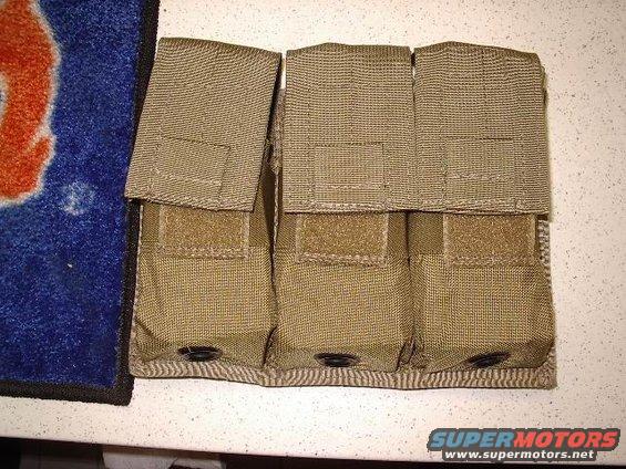 Tan tactical pouch with three compartments and velcro closures, placed on a speckled surface next to a blue and orange mat