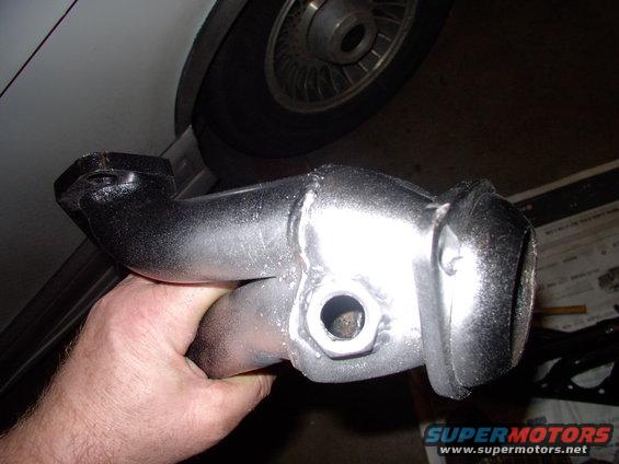 img_0215.jpg Down to the village welding shop and ten bucks later  each header had a bung welded to it. I hit them with the only high heat paint I had lying around (silver). It all burns off in a few days anyway.