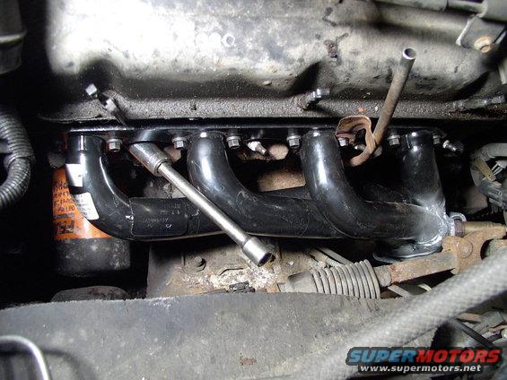 Headers bolted in and the oil dipstick tube tab judiciously bent until it fit properly.