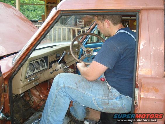 Interior of a 1984 Jeep J-10 with a man at the steering wheel