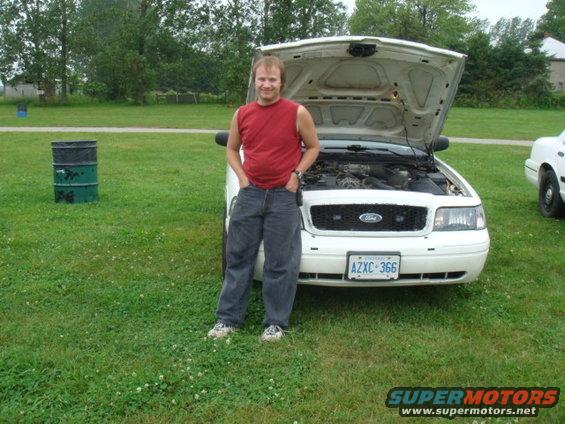 White 2004 Ford Crown Victoria with hood open, license plate AZXC 366, parked on grass