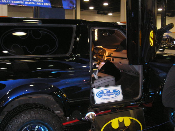 Black SUV with Batman logos and blue flames, driver's door open showing interior