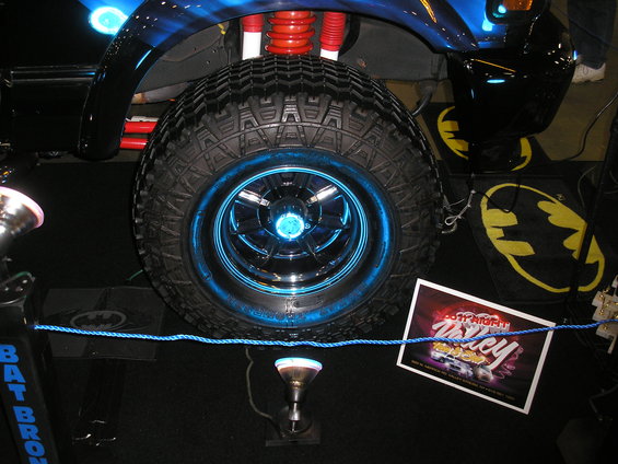 Close-up of a customized Ford Bronco wheel with blue neon lighting and off-road tire