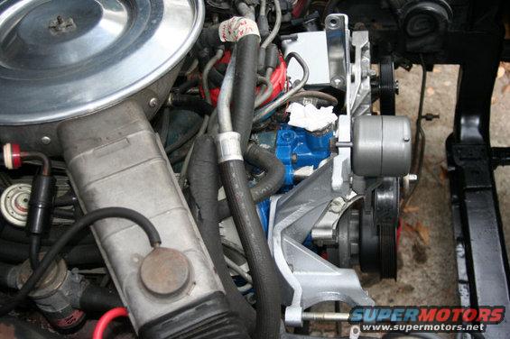 Close-up of a vehicle's engine bay, showing hoses, belts, and engine components