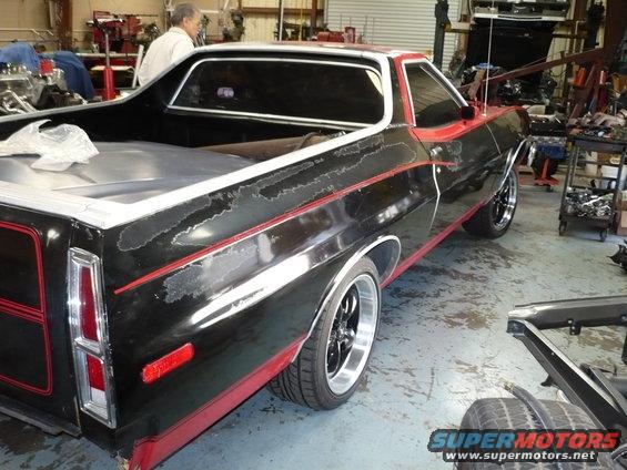 Black and red 1973 Ford Ranchero with peeling paint, seen from the rear quarter