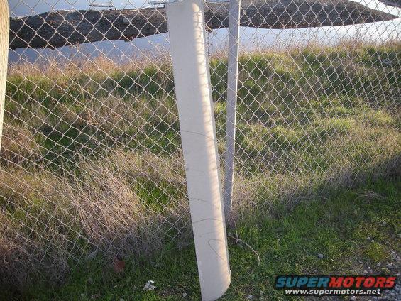 concrete fence post next to chain-link fence and dry grass