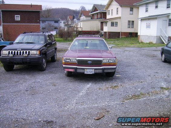 1988 Ford Crown Victoria LTD parked next to a Jeep Grand Cherokee