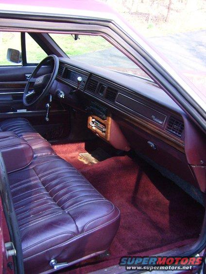 Maroon velour interior of a 1988 Ford Crown Victoria LTD, showing the dashboard, steering wheel, and front seats