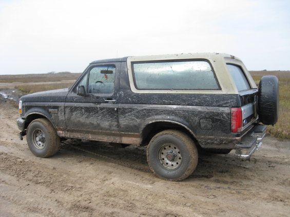 Mud-covered 1994 Ford Bronco parked on a dirt road
