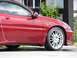 1993 Mazda MX-3 - Side profile of a red 1993 Mazda MX-3, focusing on the front quarter panel and door.