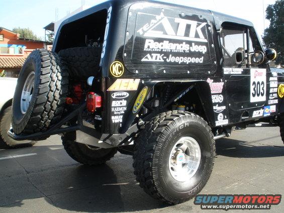 Black Jeep Wrangler with racing decals and spare tire on rear