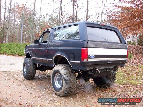 1992 Ford Bronco lifted with large tires, seen from rear 3/4 angle