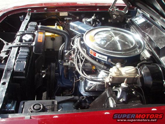 engine bay with V8 engine, air cleaner, radiator, and battery