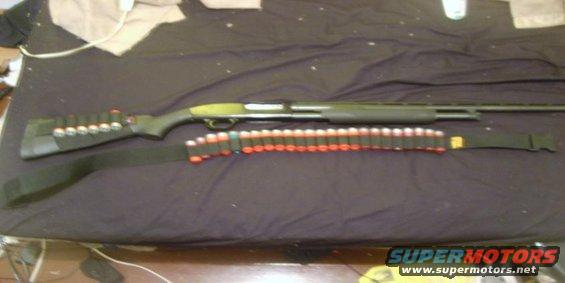 Shotgun with a black sling and a bandolier holding red-tipped shells