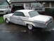 1964 Ford Fairlane - A 1963 Ford Falcon coupe in primer sits on a wet driveway, with other vehicles and a house in the background.