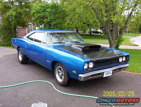 Blue 1969 Dodge Coronet with a black hood scoop and chrome bumper parked on asphalt